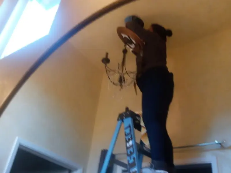 Electrician installing a chandelier in a Lawndale residence